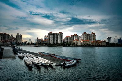 Scenic view of river by buildings against sky