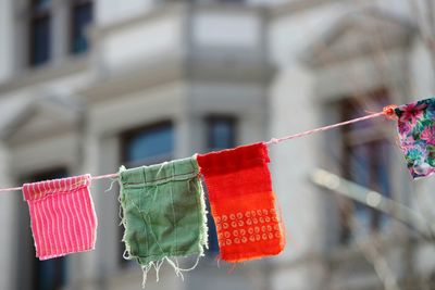 Close-up of clothes drying on rope against building