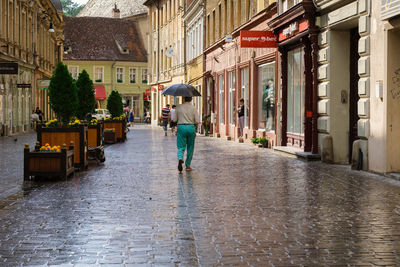 Rear view of man walking on wet street