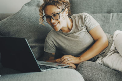 Portrait of young woman using laptop at home