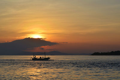 Boat sailing in sea at sunset