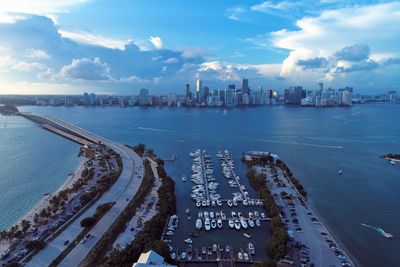 Aerial view of city by sea against sky