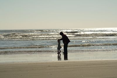 Man standing on beach against clear sky