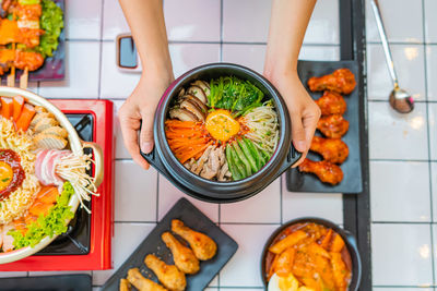 High angle view of woman holding food on table