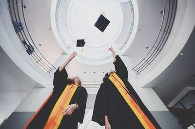 Low angle view of people standing on staircase in building