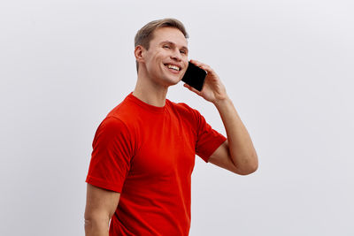 Portrait of young man standing against white background