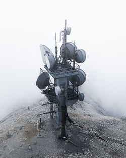 High angle view of telecommunications tower on mountain during foggy weather