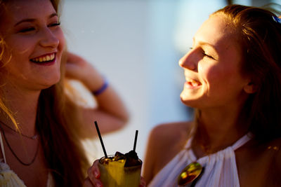 Close-up of happy female friends enjoying drink