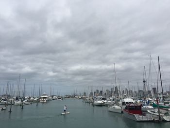 Boats moored in harbor against sky
