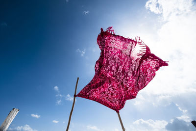 Low angle view of red umbrella against sky