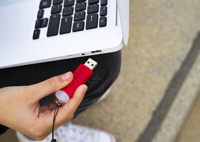 Hand connecting a pendrive to the laptop.