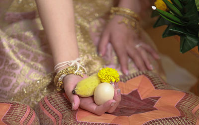 Midsection of bride holding religious offering during wedding ceremony
