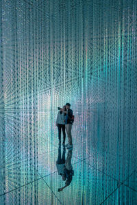 Full length of a man with woman standing by water