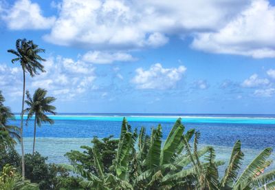 Scenic view of calm beach against cloudy sky