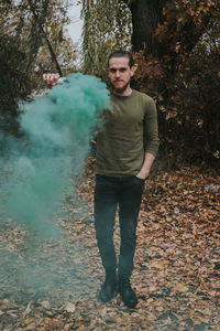 Portrait of young man standing in forest