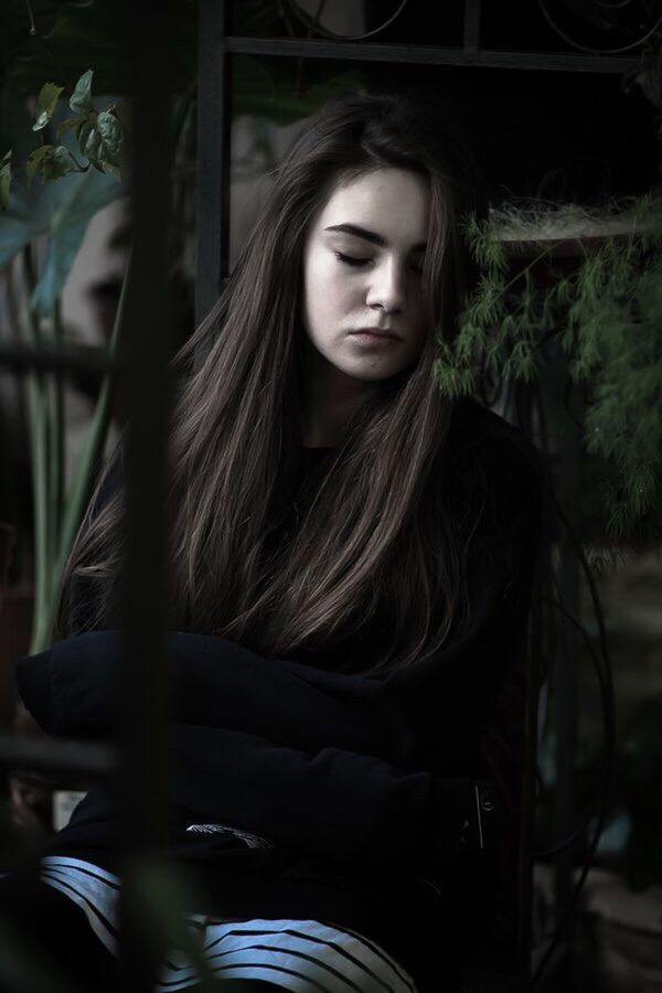 BEAUTIFUL YOUNG WOMAN WITH EYES CLOSED IN BACKGROUND