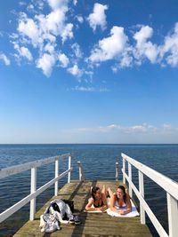 People by sea against sky