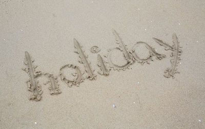 High angle view of text on sand at beach