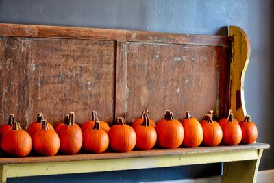 Close-up of pumpkins arranged in row on wood