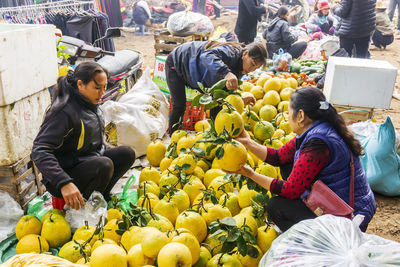 Full length of people sitting at market stall