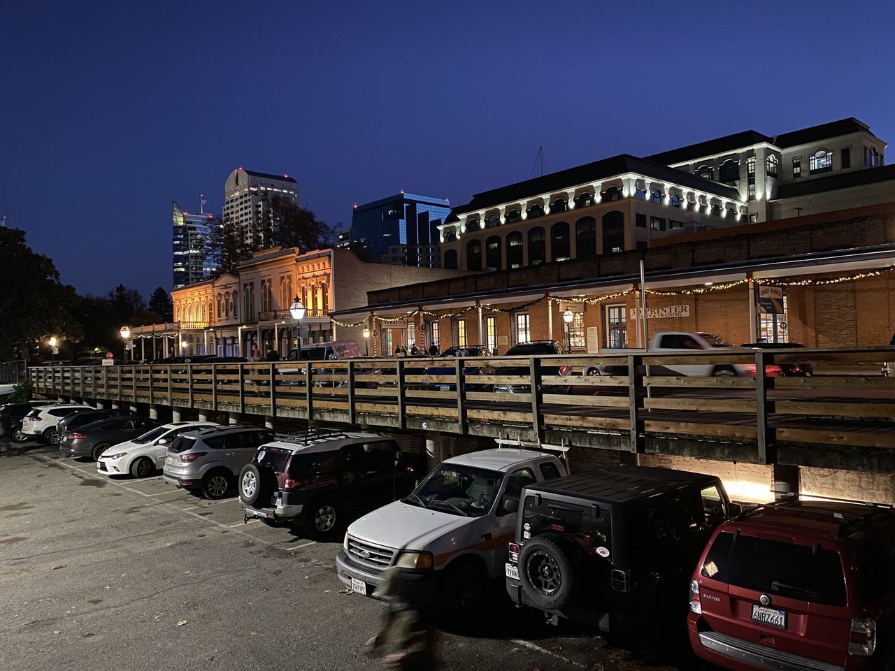 CARS PARKED ON ILLUMINATED STREET BY BUILDINGS AT NIGHT