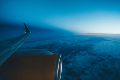 Airplane flying over sea against blue sky