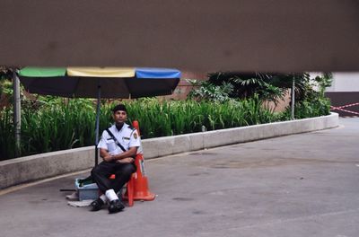 Full length of man sitting outdoors