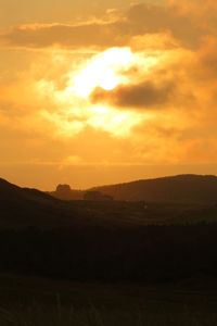 Scenic view of mountains against sky at sunset