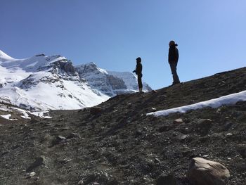Low angle view of people on snow covered mountain