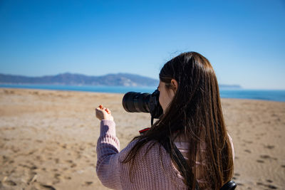 Side view of woman looking at sea against sky