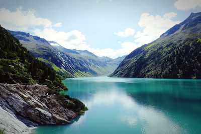 Scenic view of lake by mountains against sky