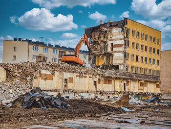Yellow excavator destroys armored concrete to open doors new possibilities