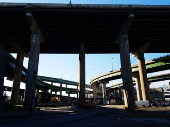 Low angle view of bridge in city against sky