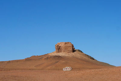 View of desert against clear blue sky