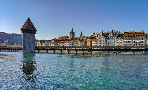 View of river and buildings against blue sky