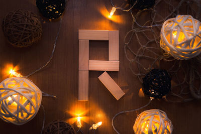 Directly above shot of letter r blocks and illuminated lights on wooden table