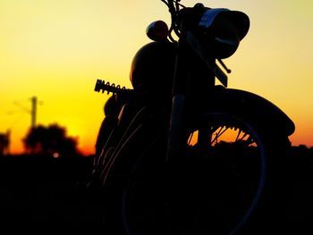 Silhouette man riding bicycle against clear sky during sunset