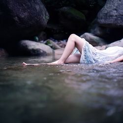 Low section of woman relaxing on water