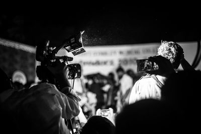 Rear view of photographer with camera during ceremony