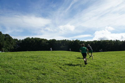 Man on golf course on field against sky