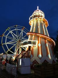 Low angle view of illuminated ferris wheel against sky at night