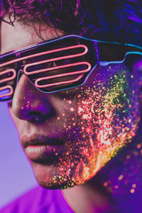 Close-up of man with multi colored face paint wearing eyewear