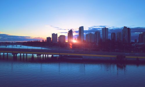 View of buildings at waterfront during sunset