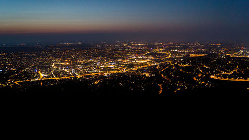 Aerial view of illuminated cityscape against sky at night