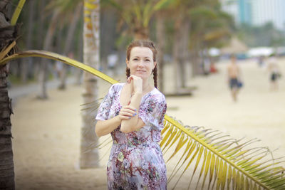 Portrait of smiling young woman standing at beach