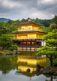 Built structure by lake against sky