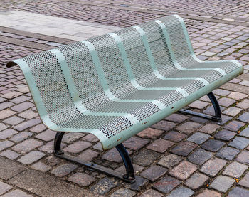 High angle view of empty chair on sidewalk