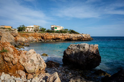 Rocks by sea against sky