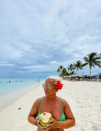 Woman wearing sunglasses on beach against sky