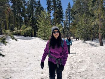 Two women hiking through a winter landscape in the sierra nevada mountains near lake tahoe